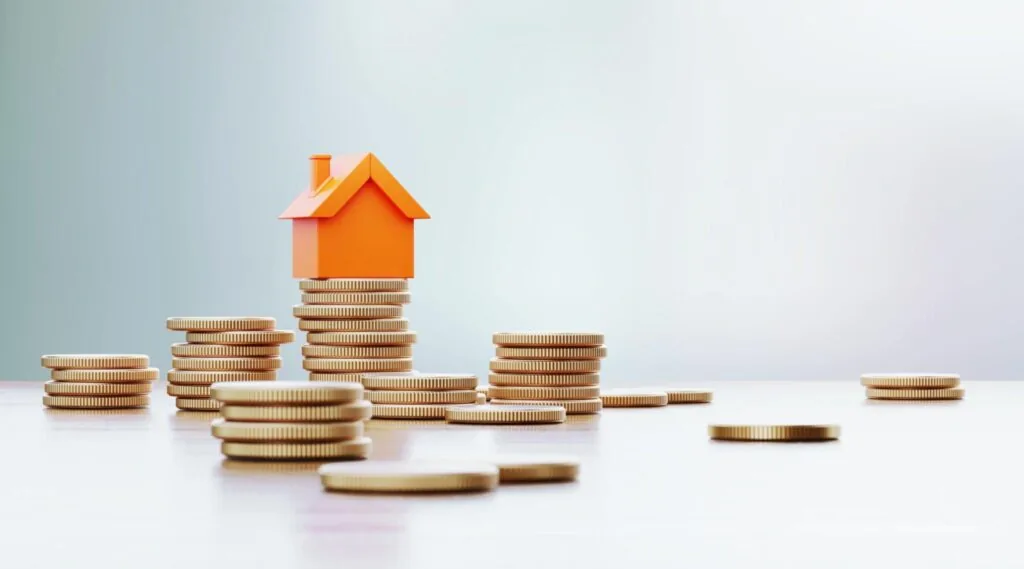 buying a house - toy house is sitting over coin stacks