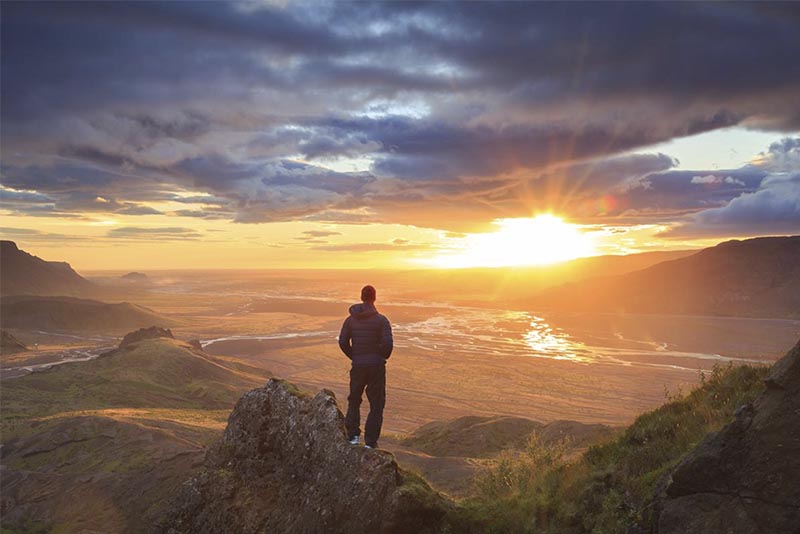 Man looking at sunset from mountain