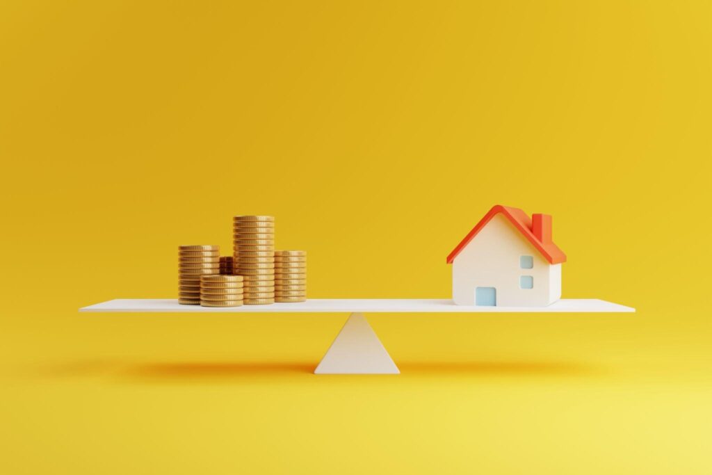 Buying a House Without a Loan - House and coin on balancing scale on yellow background. Real estate business mortgage investment and financial loan concept.